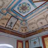 Attraverso un�altra porta giungiamo in un grazioso salottino con decori in stile pompeiano
